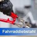 Drahtschneider in einer Hand, verschwommenes Fahrrad im Hintergrund