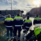 Polizisten vor untergehender Sonne über der Straße zum Bahnhof